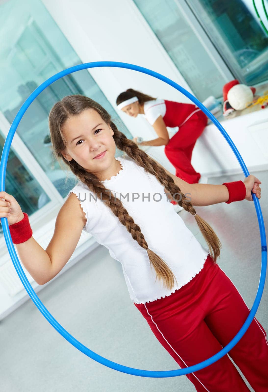 Portrait of healthy girl with blue hoop in gym