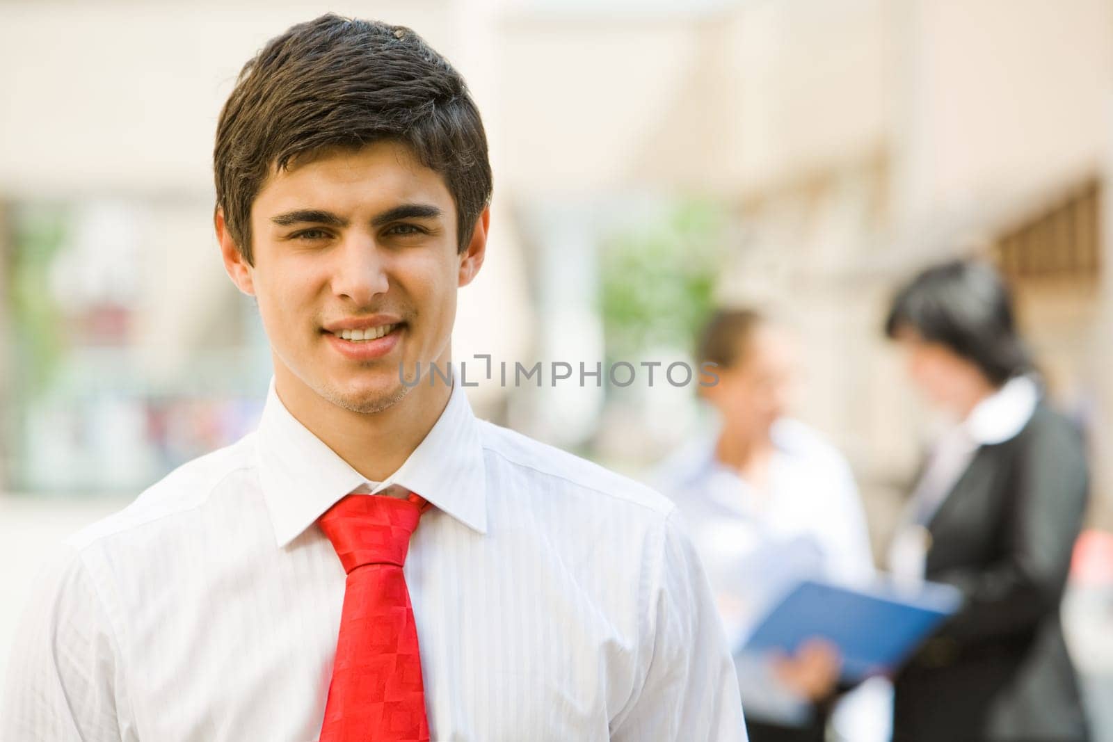 Portrait of handsome employer smiling at camera in working environment