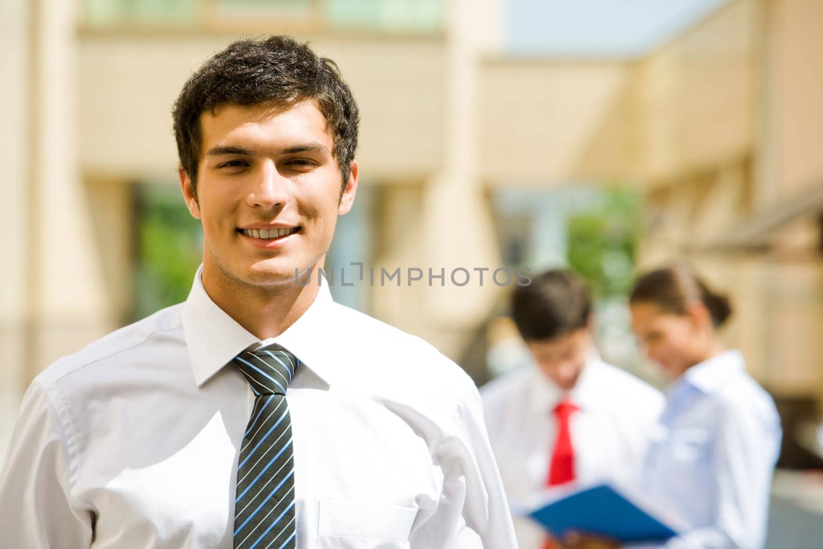 Portrait of handsome employer looking at camera with smile in working environment