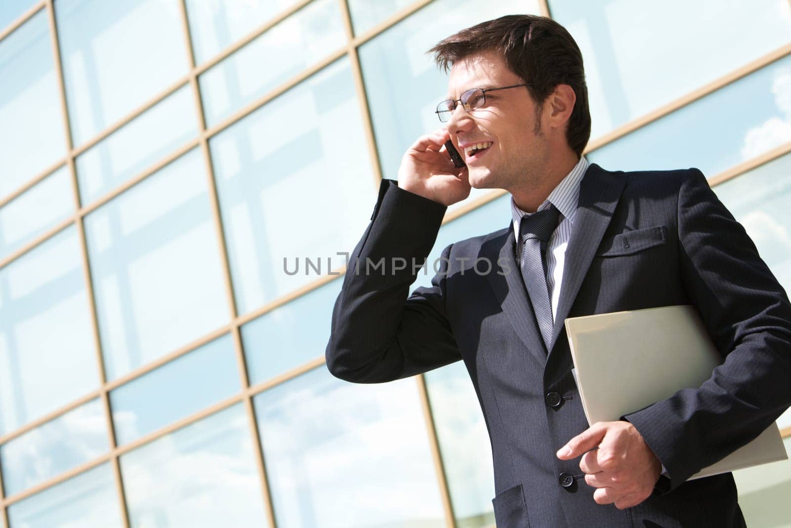 Photo of handsome employer speaking on mobile phone