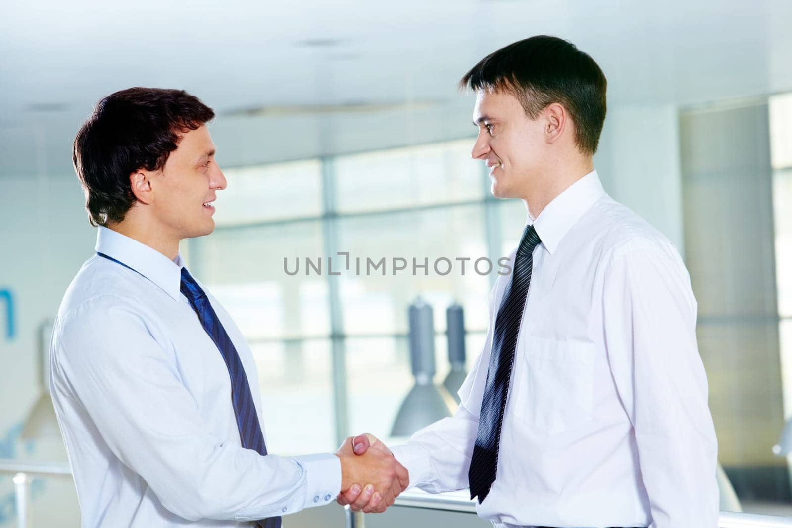 Portrait of two businessmen handshaking and greeting each other