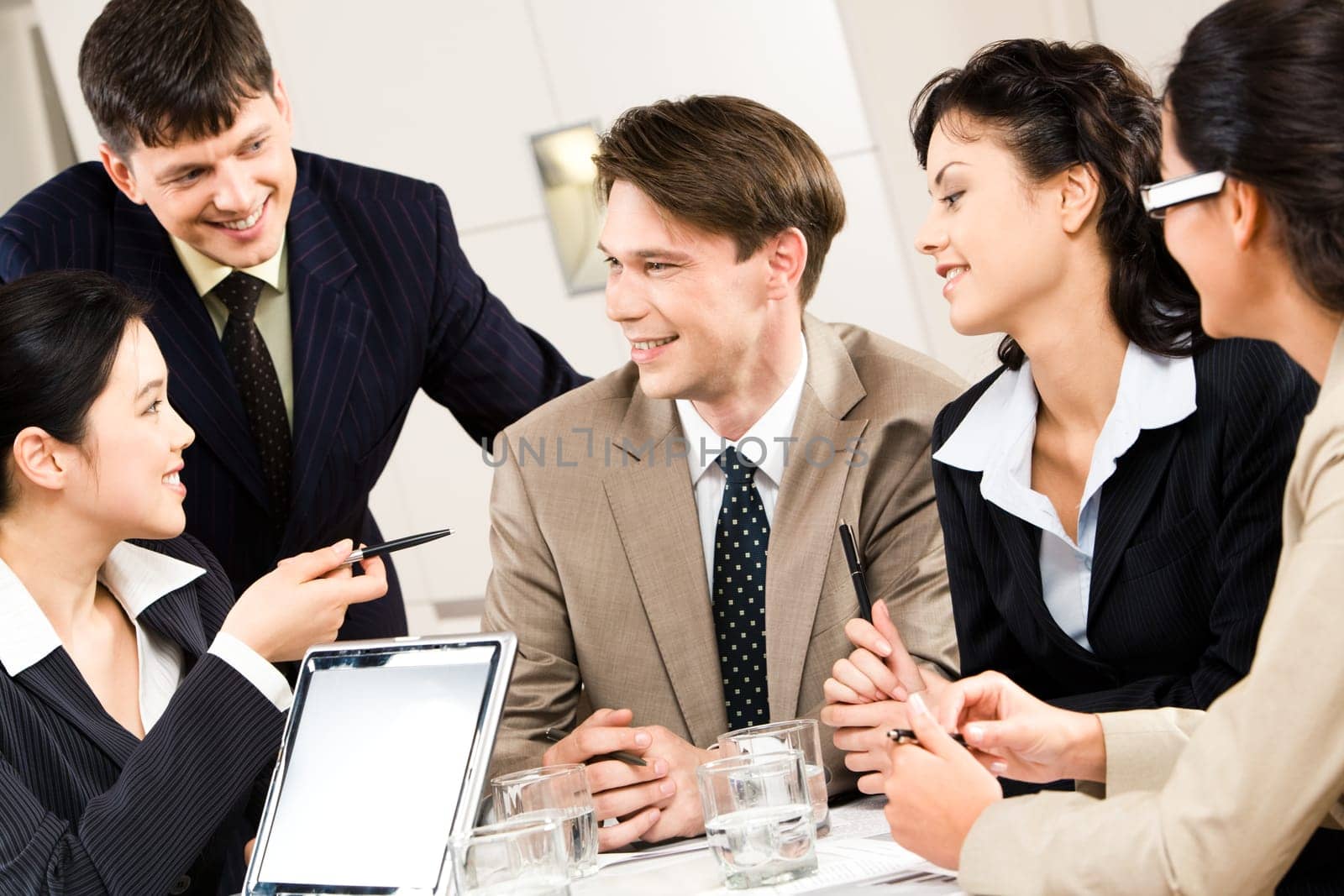Portrait of five business people discussing a project at briefing