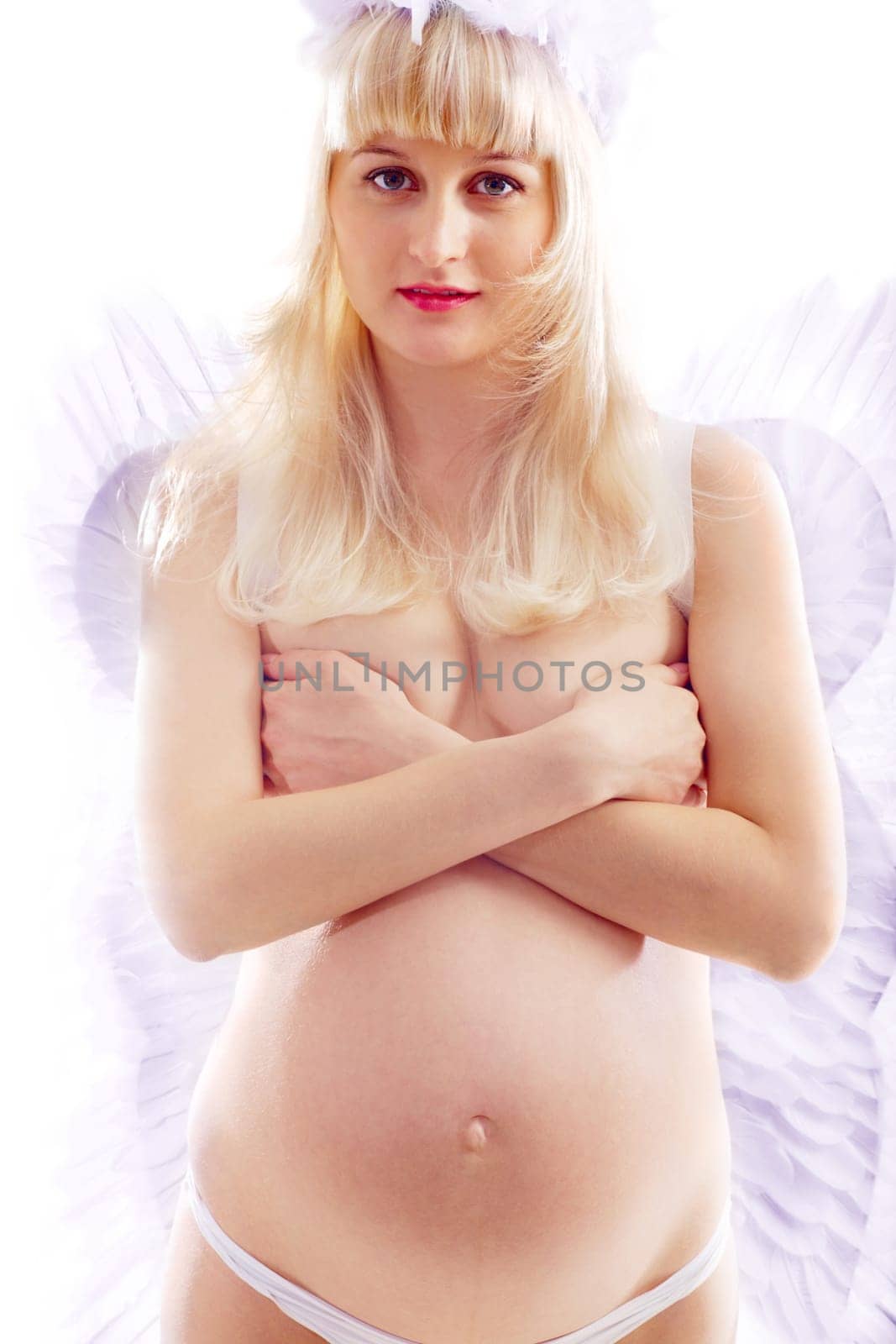 Beautiful pregnant woman with wings on white background