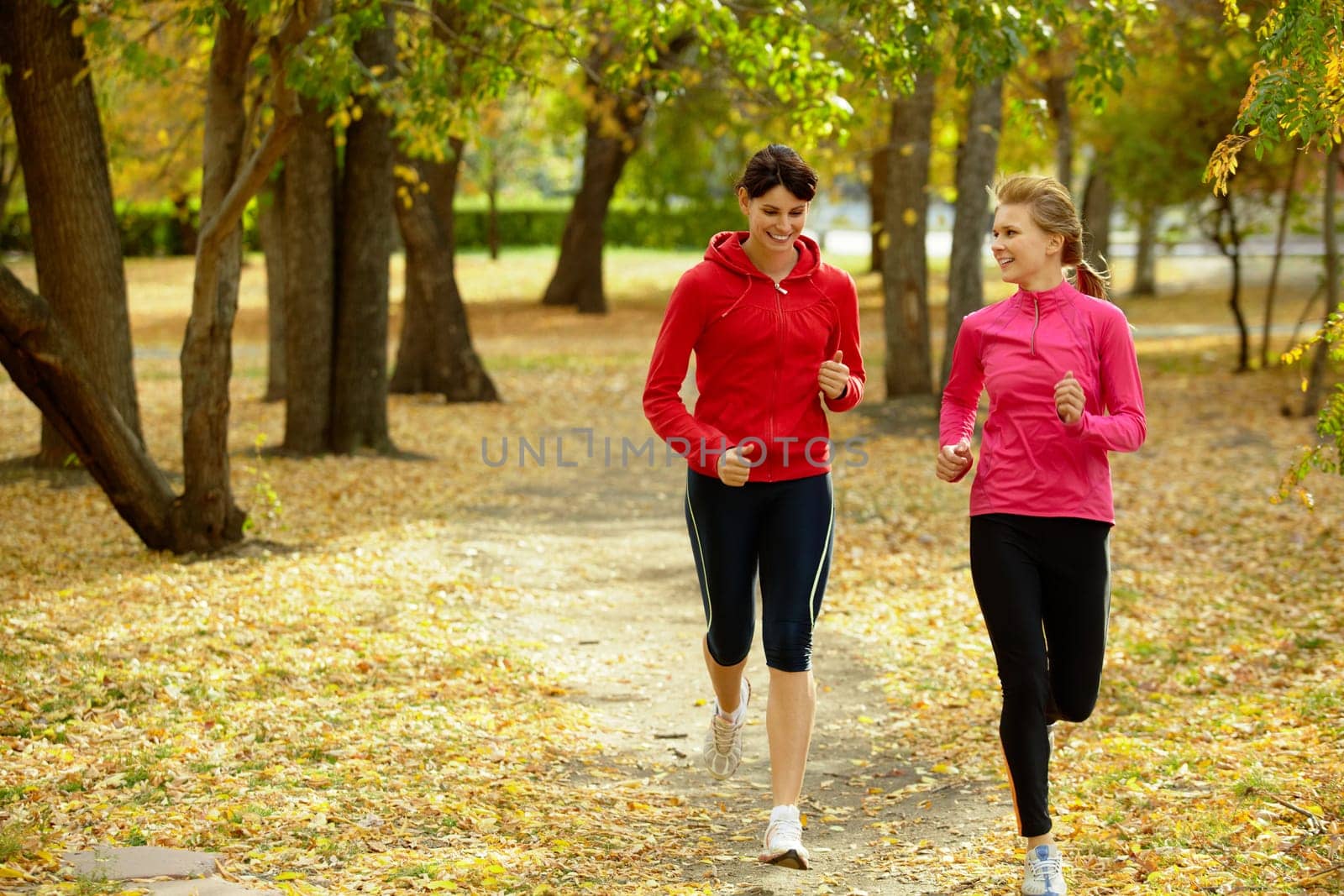 Two girls racing in autumn park