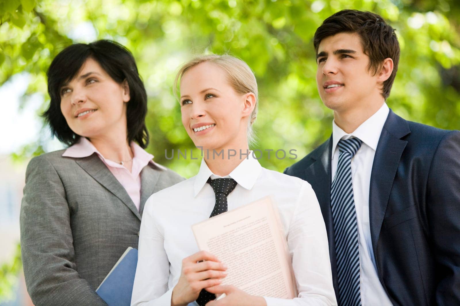 Portrait of confident business group looking aside in natural environment
