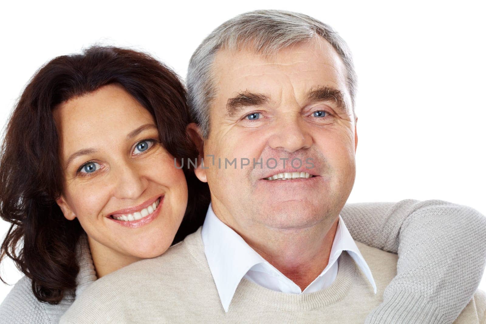 Portrait of happy mature couple looking at camera while woman embracing man