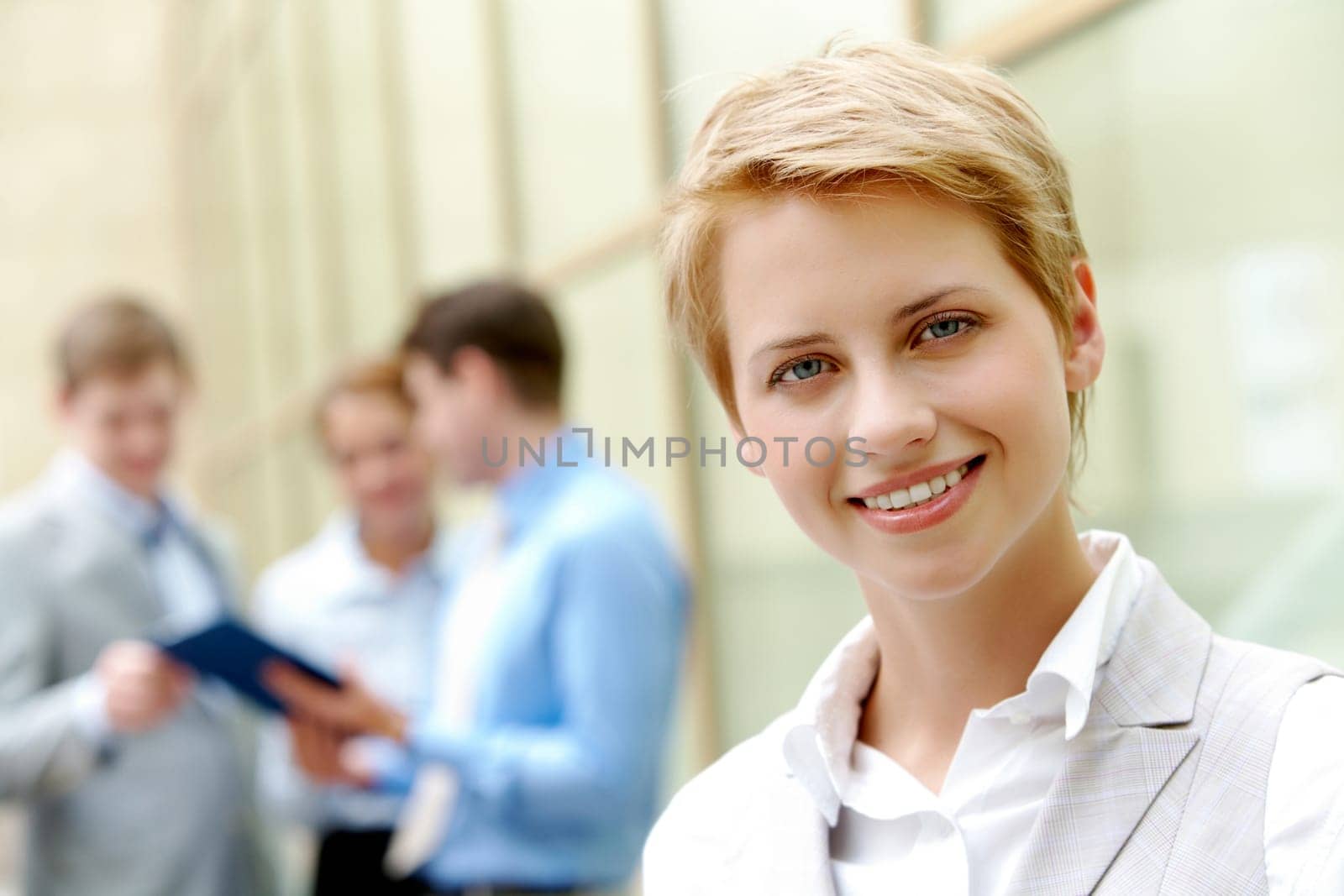 Portrait of pretty employee smiling at camera in natural environment