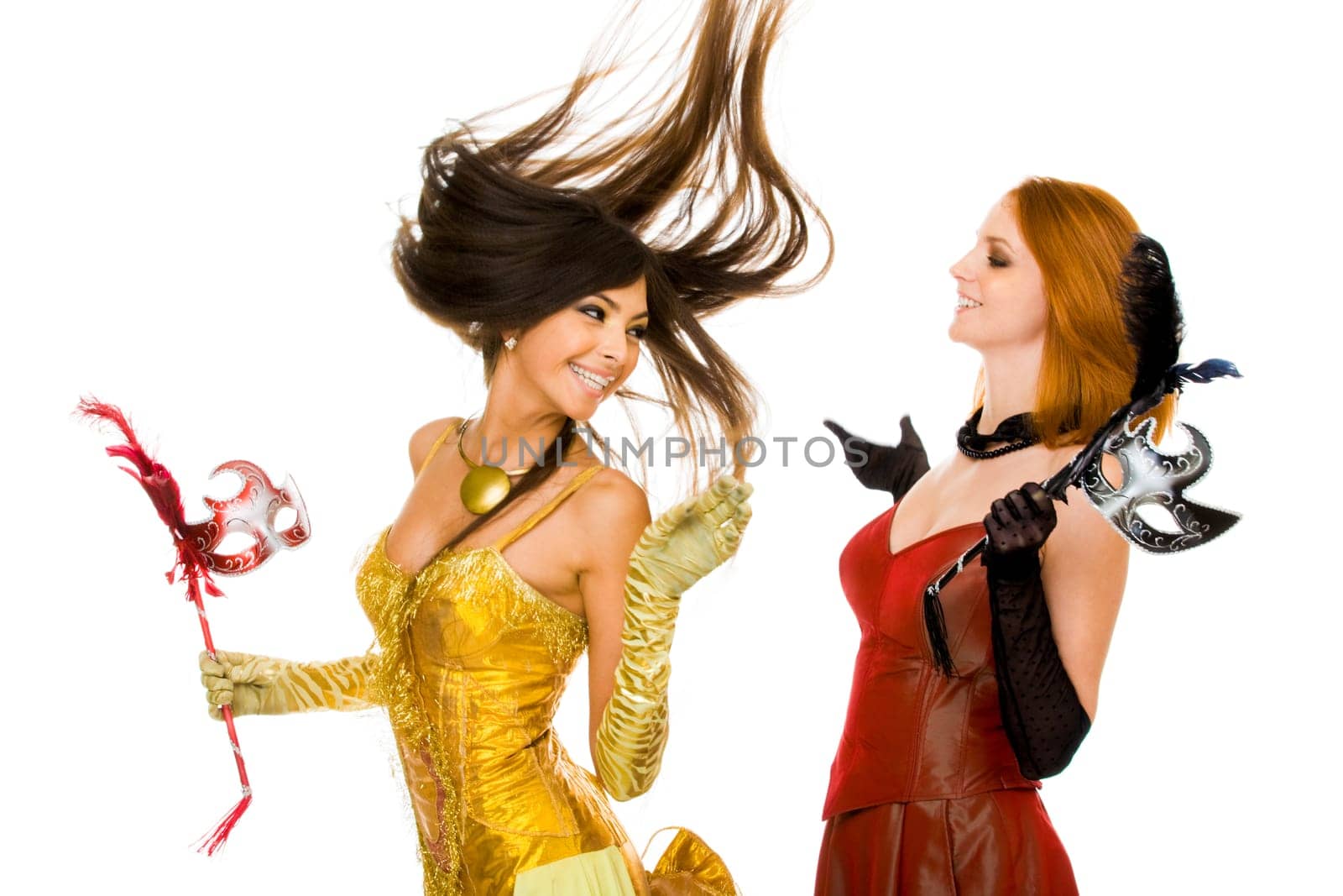 Photo of joyful actresses in fashionable dresses having fun over white background