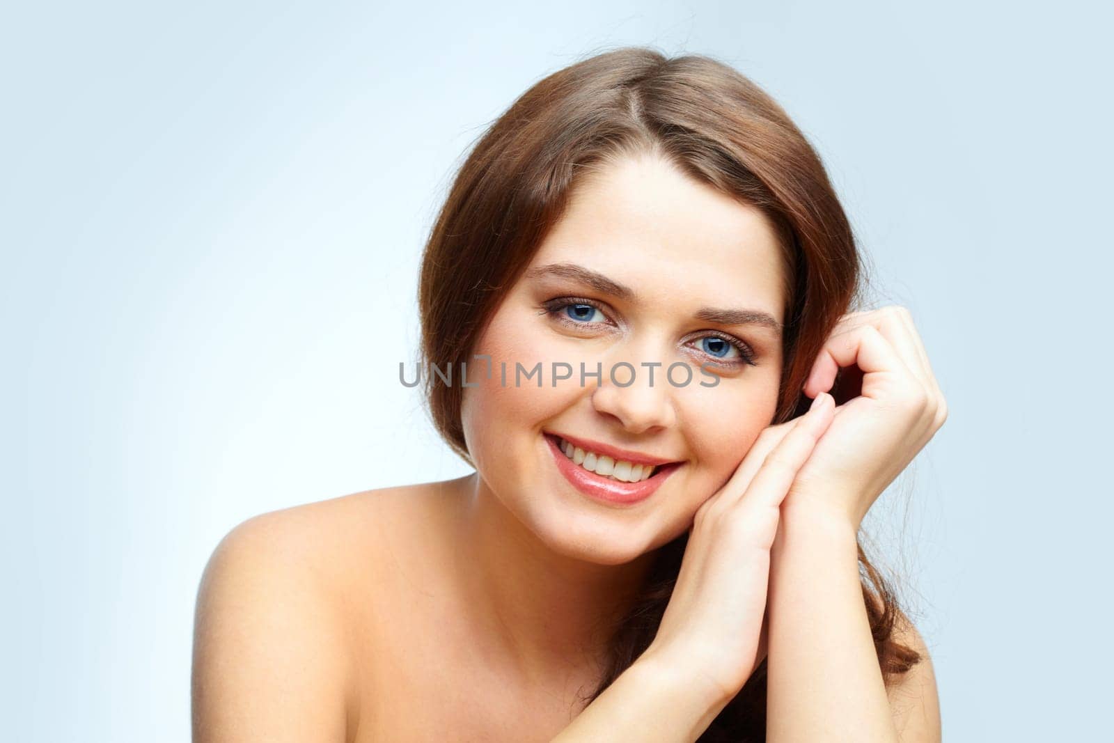 Portrait of charming girl touching her face and looking at camera