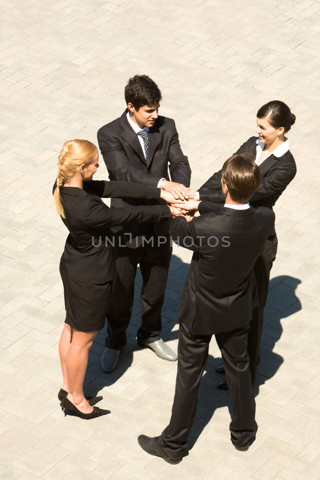 Photo of people standing and stacking their hands