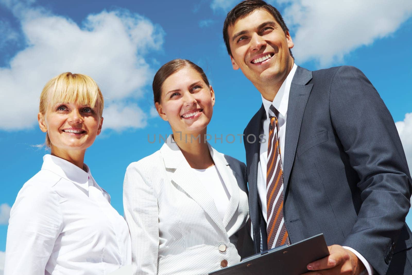Portrait of confident business group on background of cloudy sky