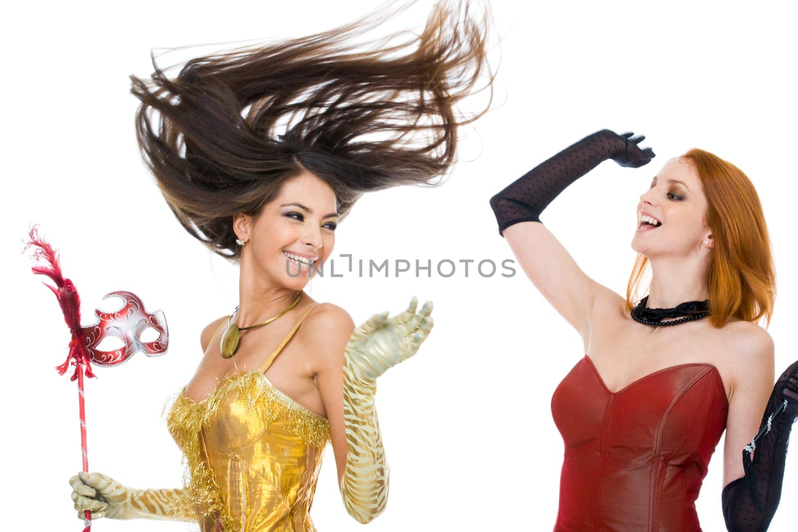 Photo of joyful actresses in fashionable dresses laughing over white background