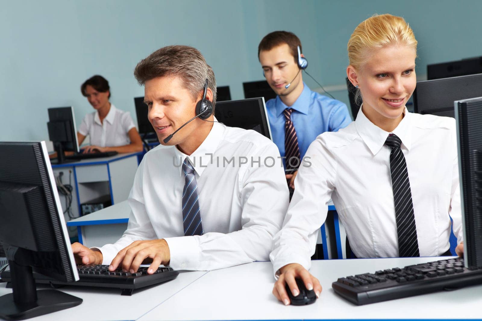 Four business people sitting in one room and working