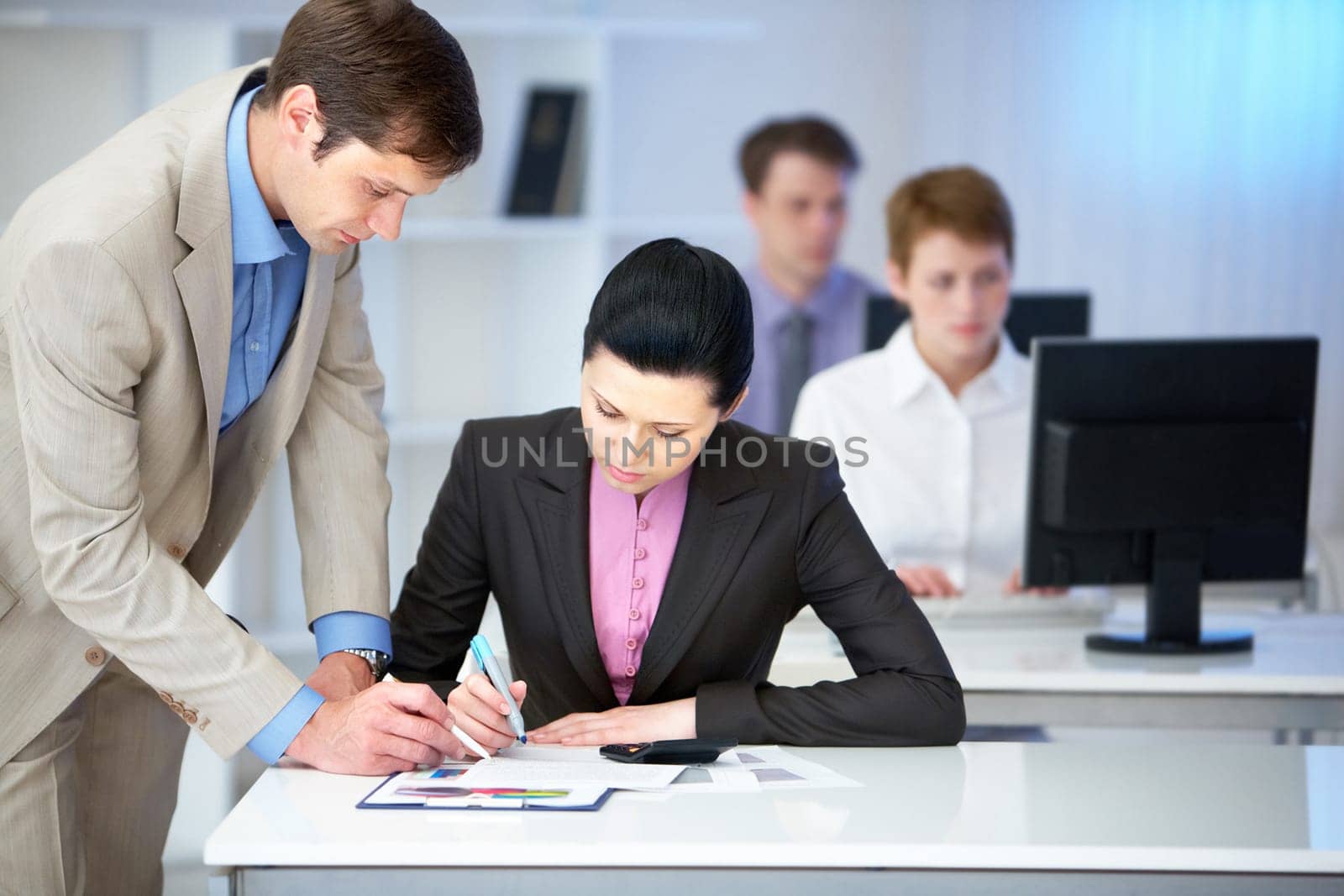 Portrait of confident businessman consulting pretty employee in office
