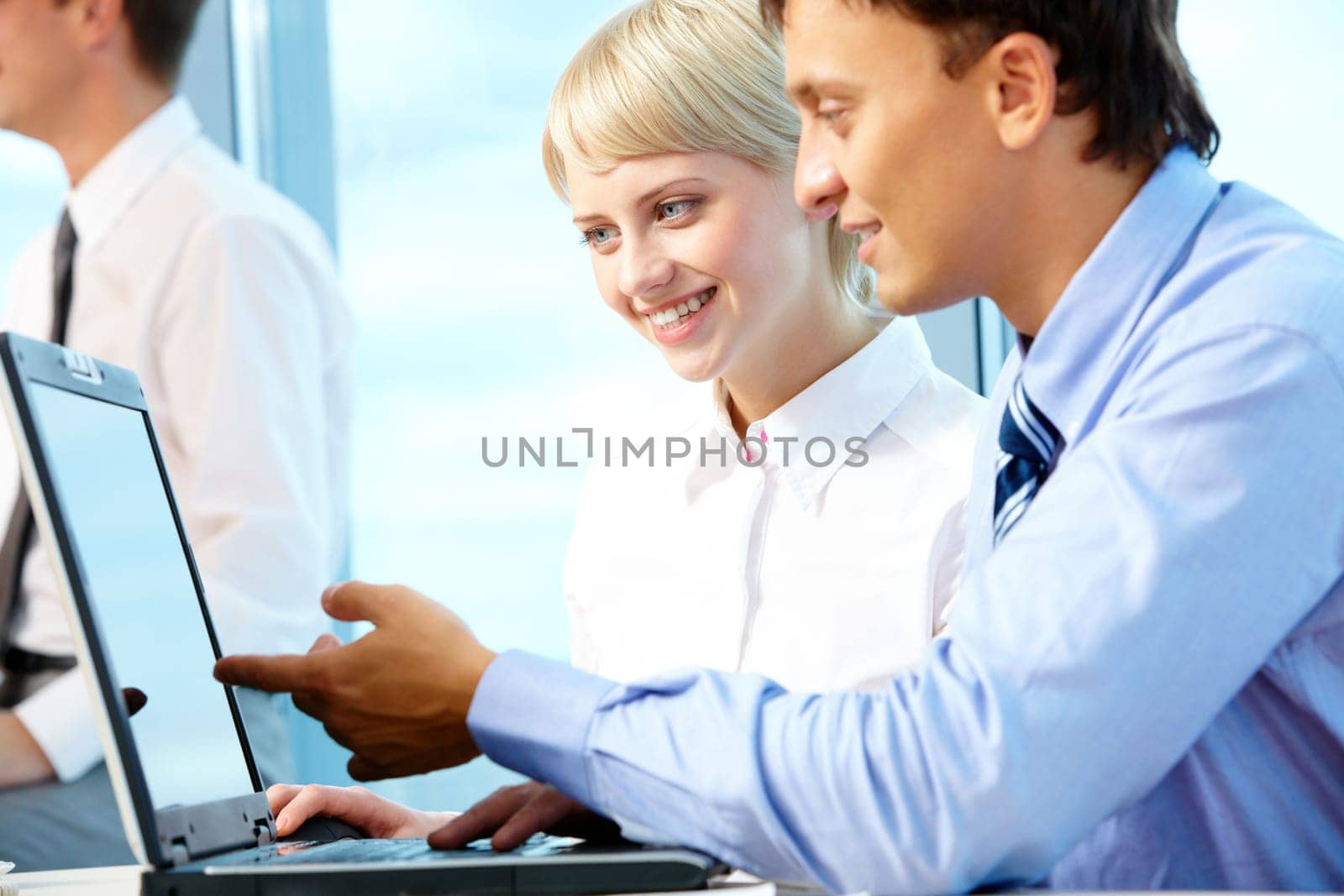 Portrait of executive partners looking at laptop during meeting
