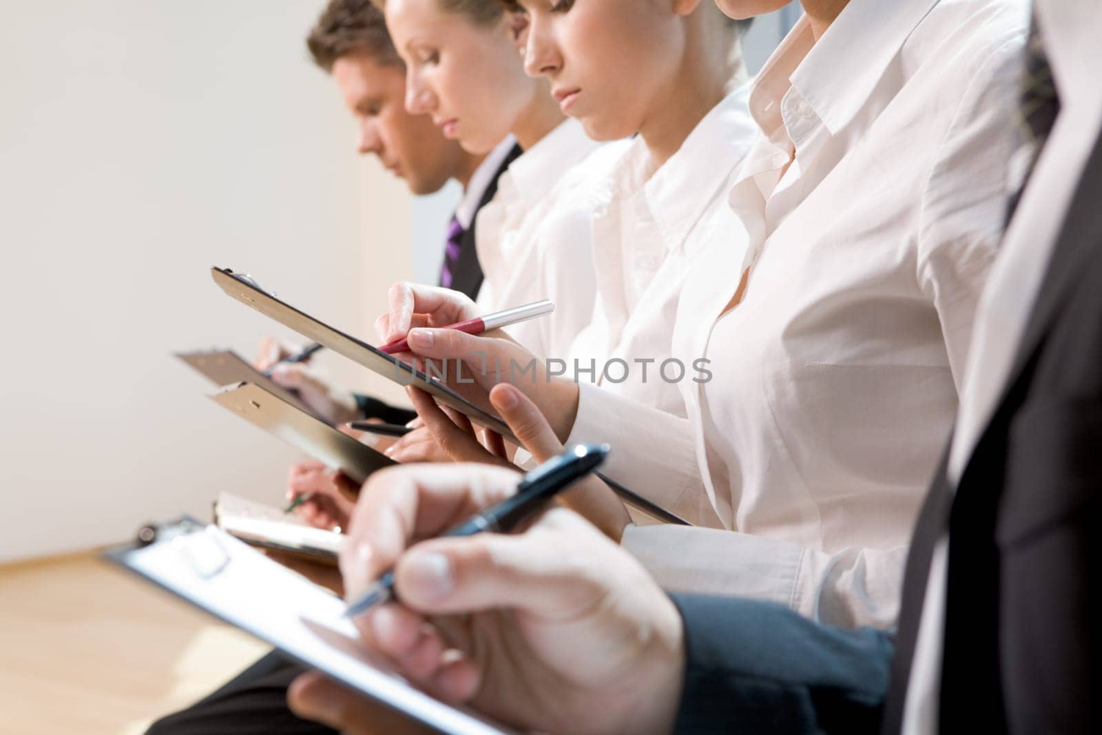 Row of business people writing lecture at seminar
