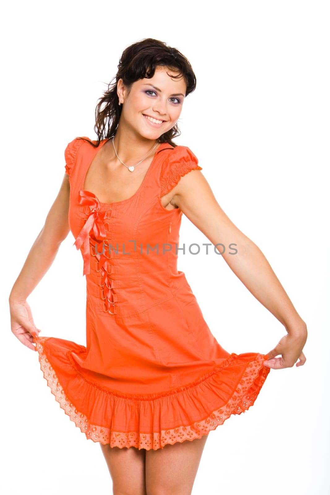 Portrait of pretty girl wearing red dress and holding its hem while looking at camera