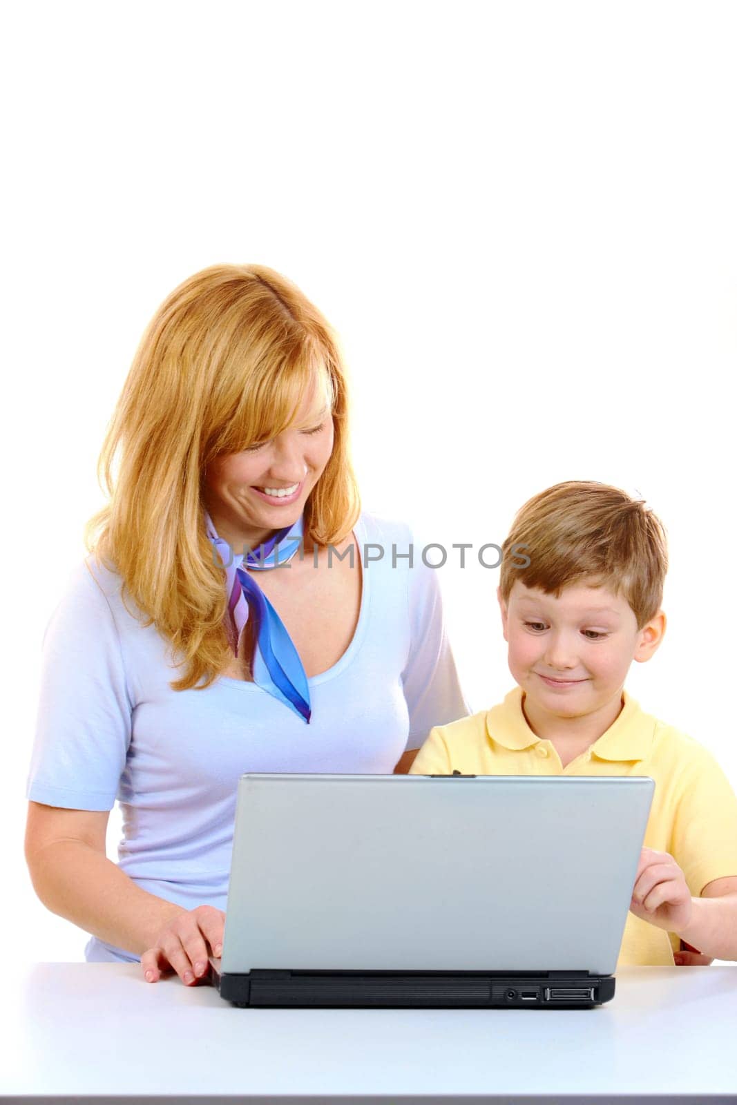 Photo of cute preschooler and his mother working with laptop