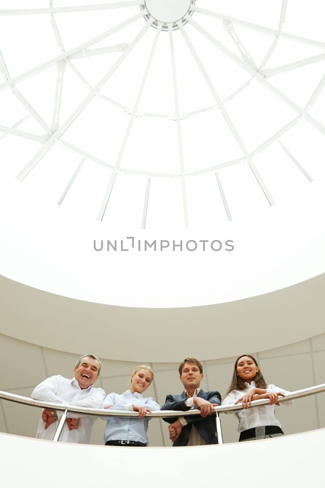 Creative image of happy business group standing together in the business hall