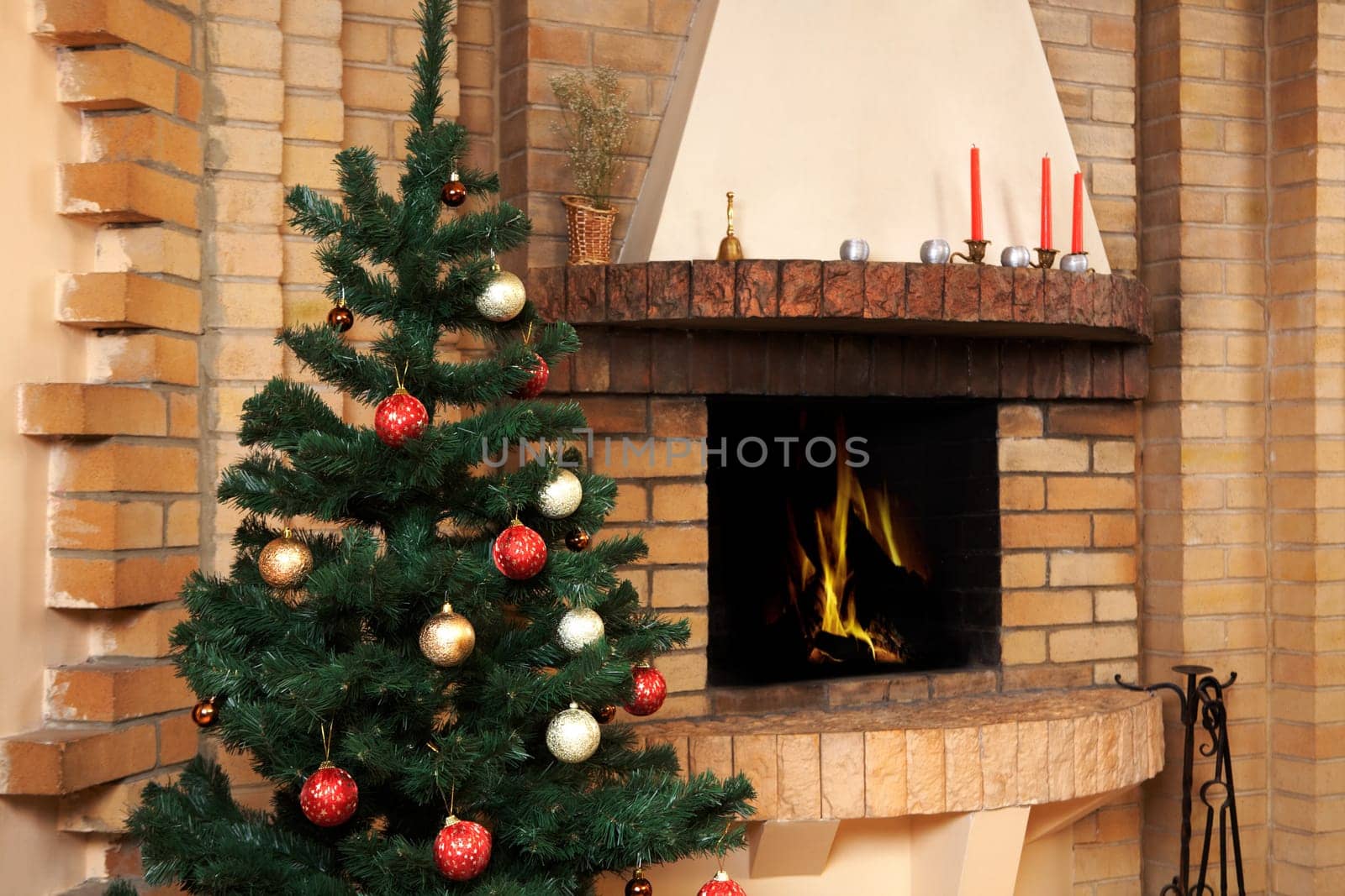Christmas room with fireplace and decorated fir tree with toys on it