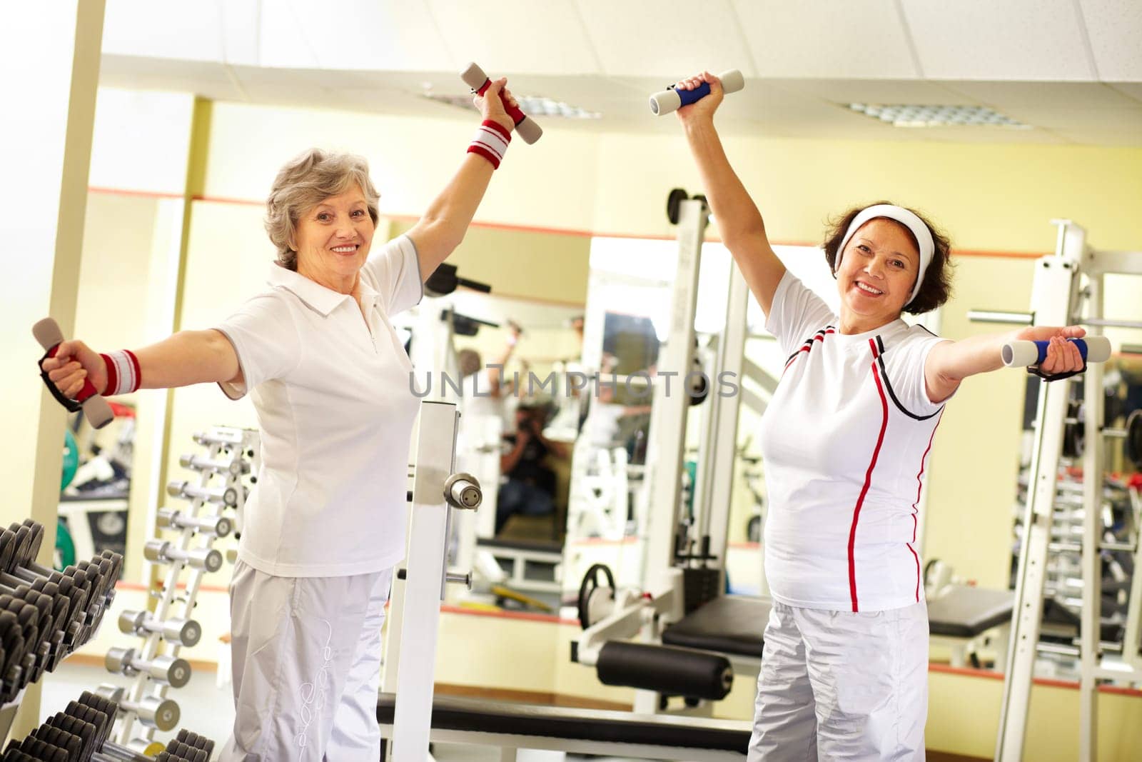 Two pretty senior women exercising with dumbbells