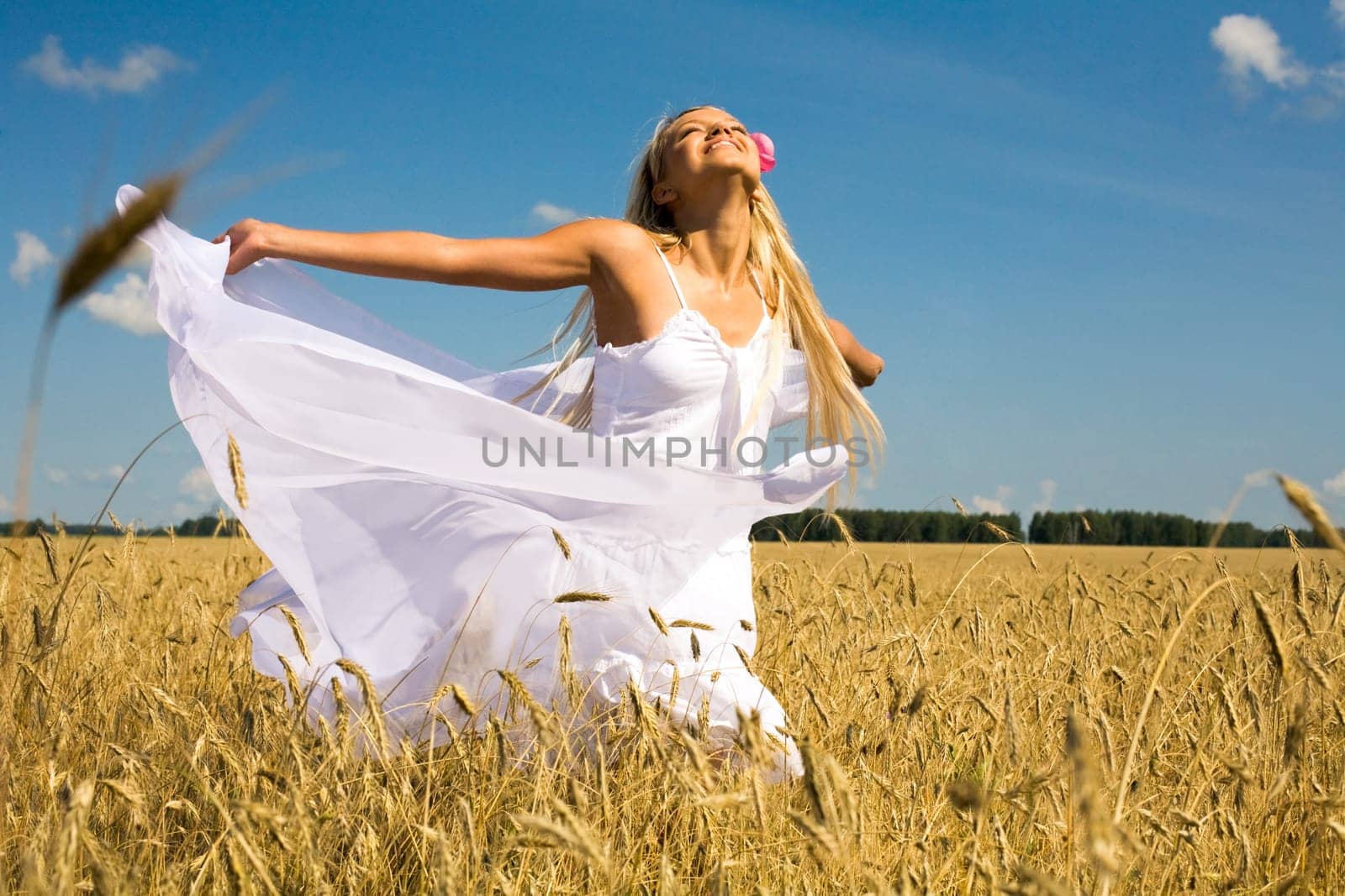 Photo of glad girl with white fabric looking upwards in wheat meadow