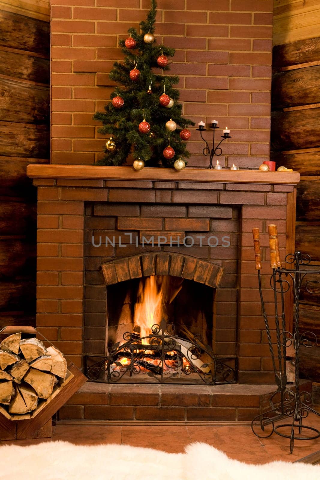 Image of hot fire in chimney with fir tree decorated before Christmas