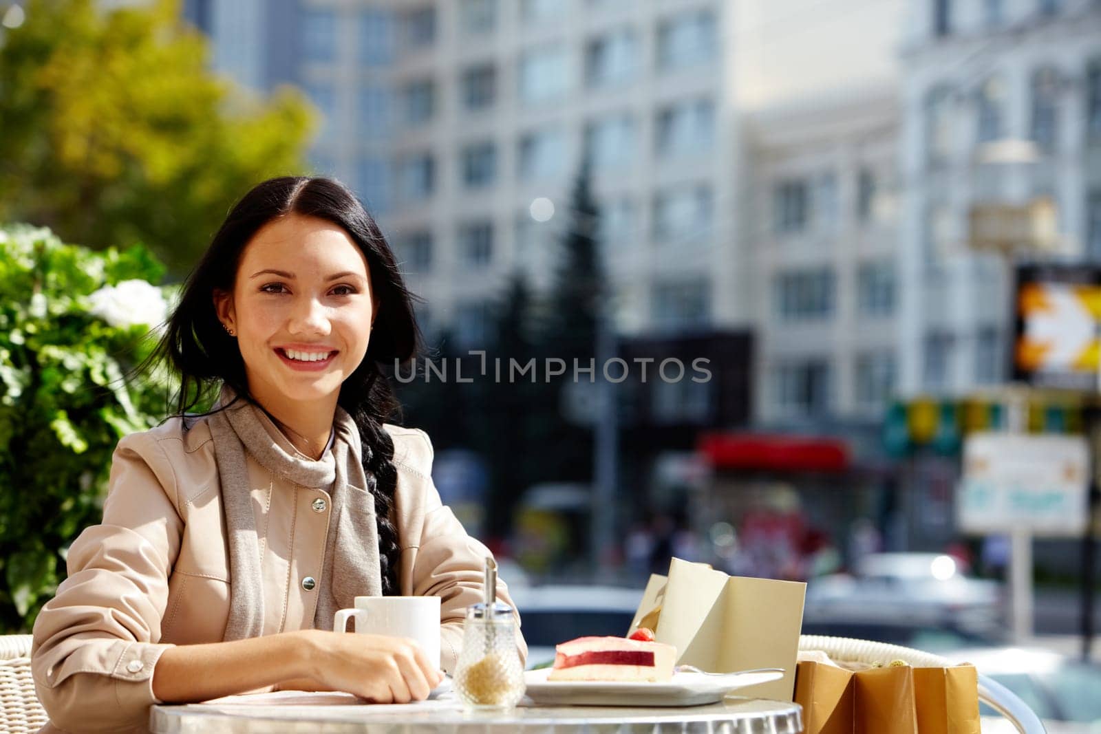 Image of happy female in open air cafe looking at camera in urban environment