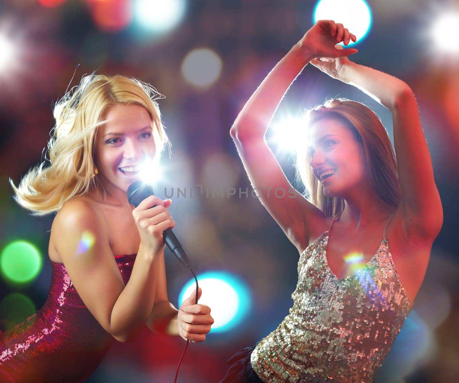 Two young beautiful girls dancing and singing