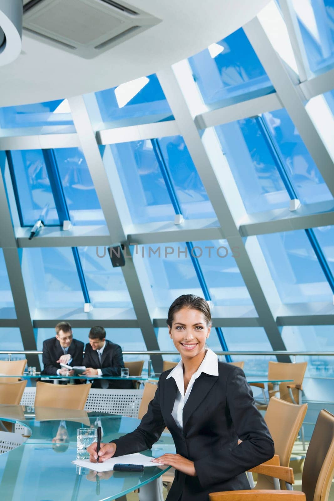 Confident woman is writing a text in the conference room
