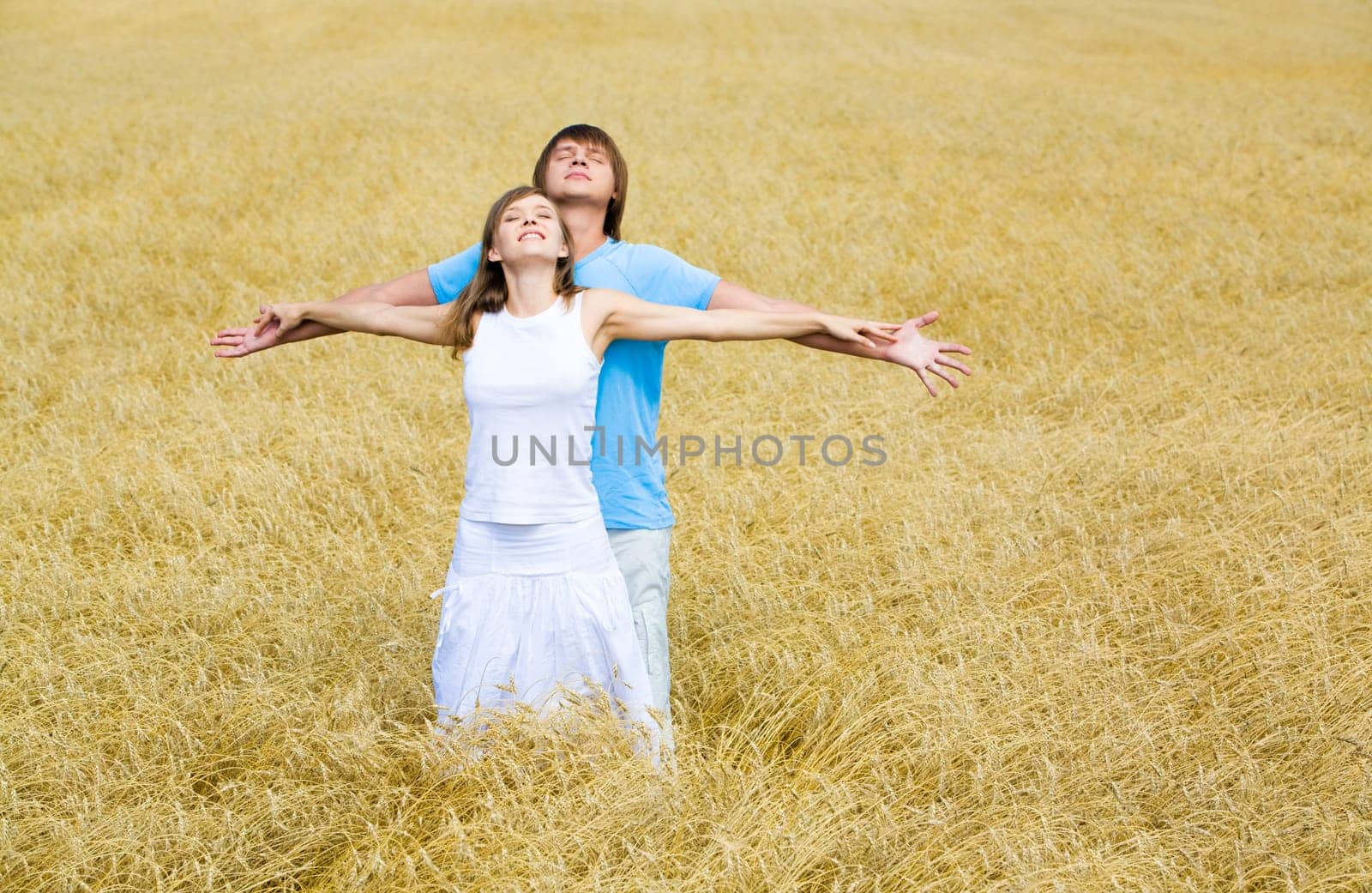 Image of couple raising their hands and enjoying weather