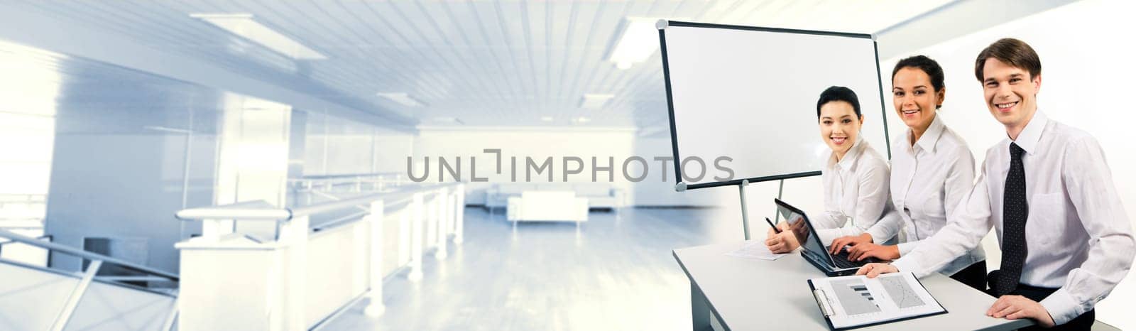 Photo of confident business team sitting at desk and looking at camera with smiles