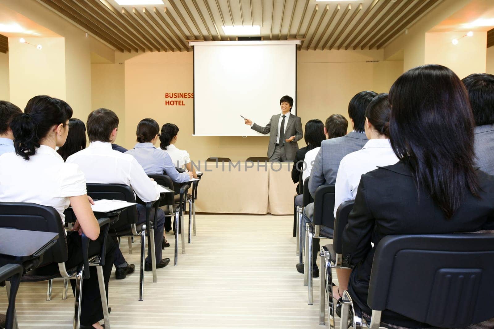 Image of confident businessman explaining something on whiteboard during conference