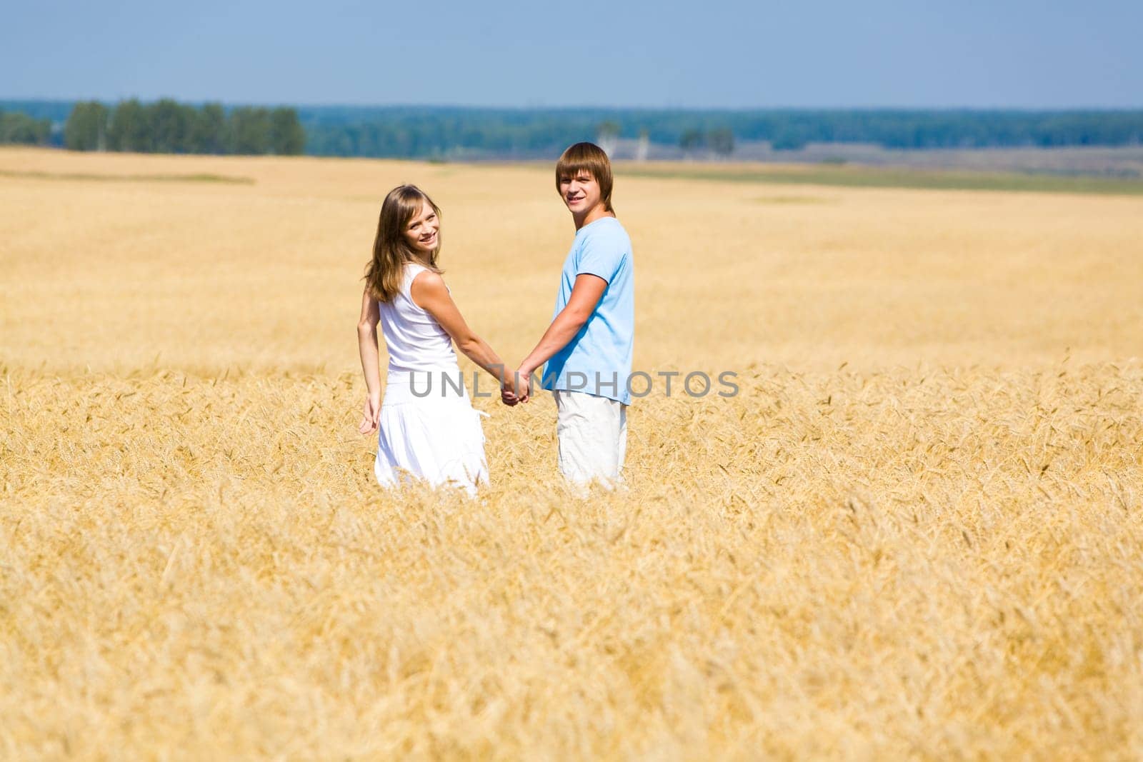 Portrait of two people standing together in wheat field