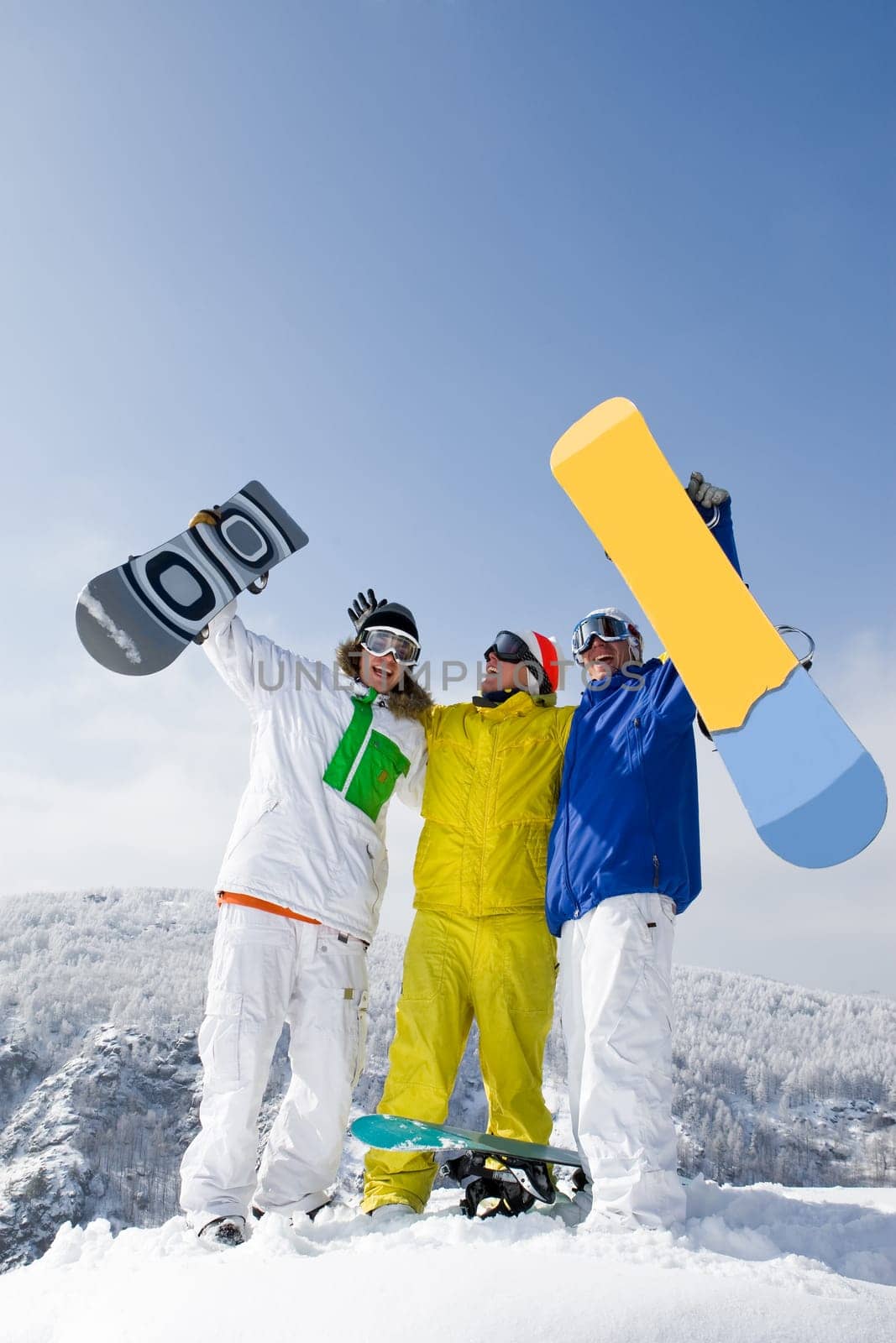 Portrait of three successful snowboarders raising their arms on mountain top