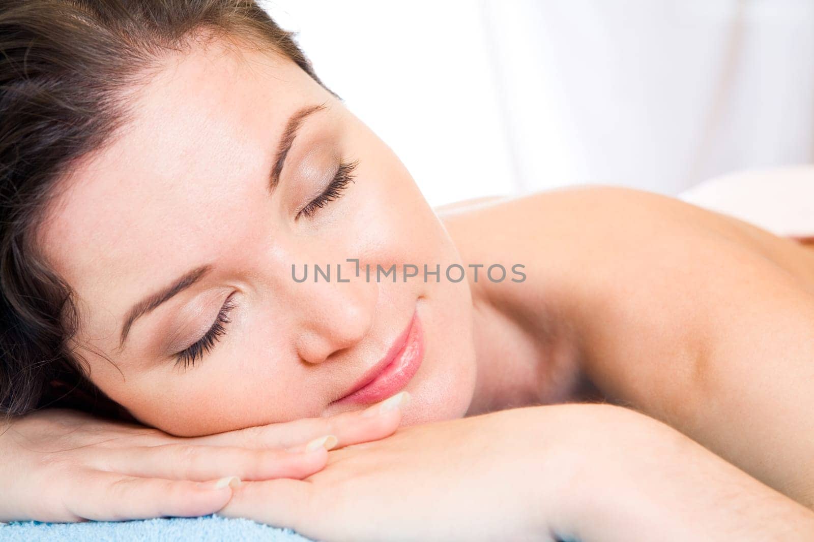 Beautiful woman with her eyes shut having rest in the spa salon