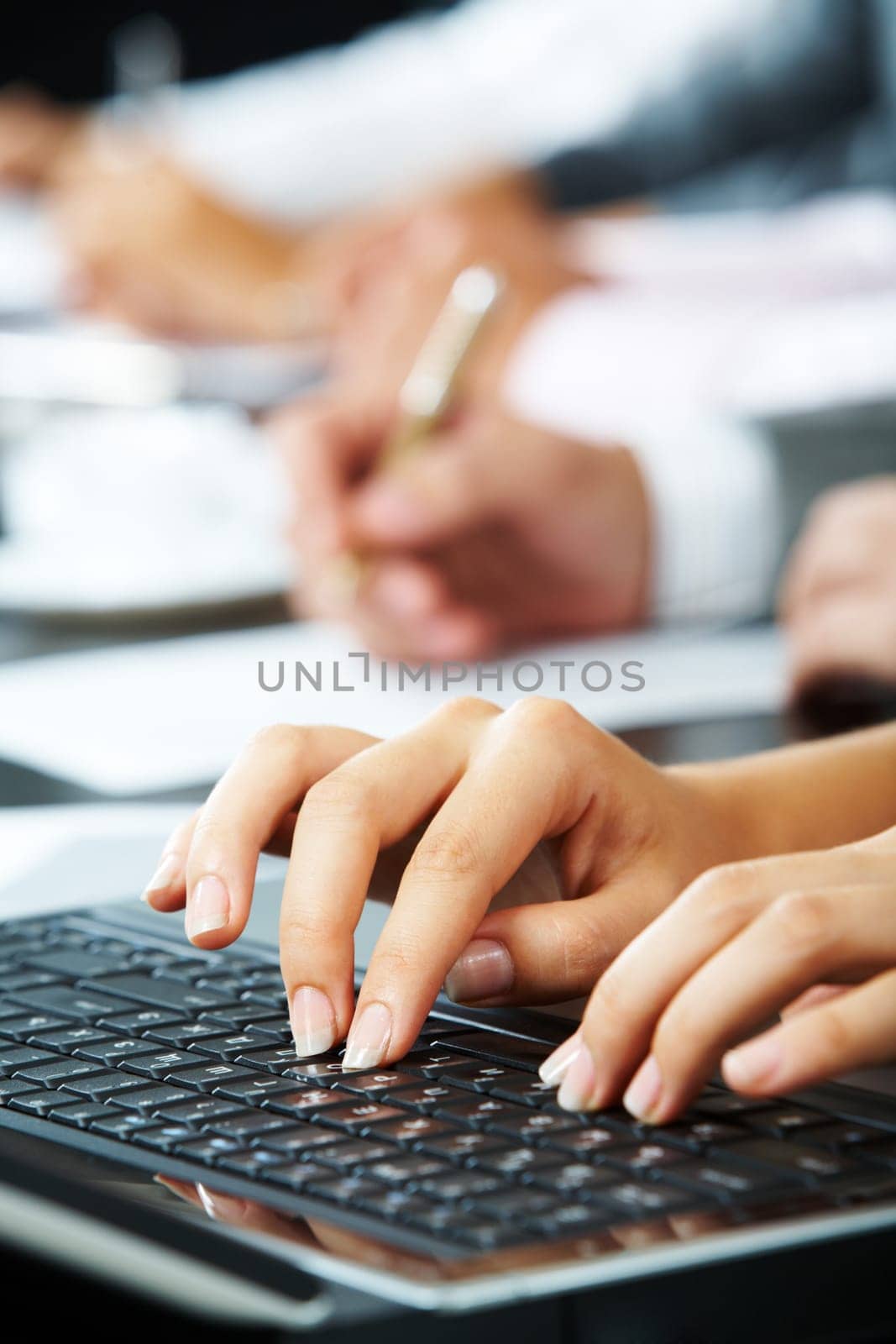 Photo of females hands touching keys of laptop during briefing on background of human hands