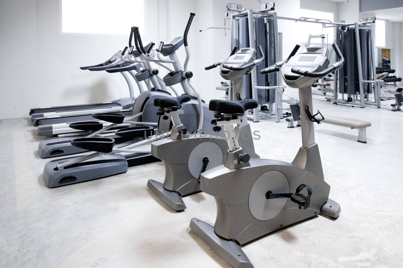 elliptical cross trainer, stationary bicycle and treadmill in gym