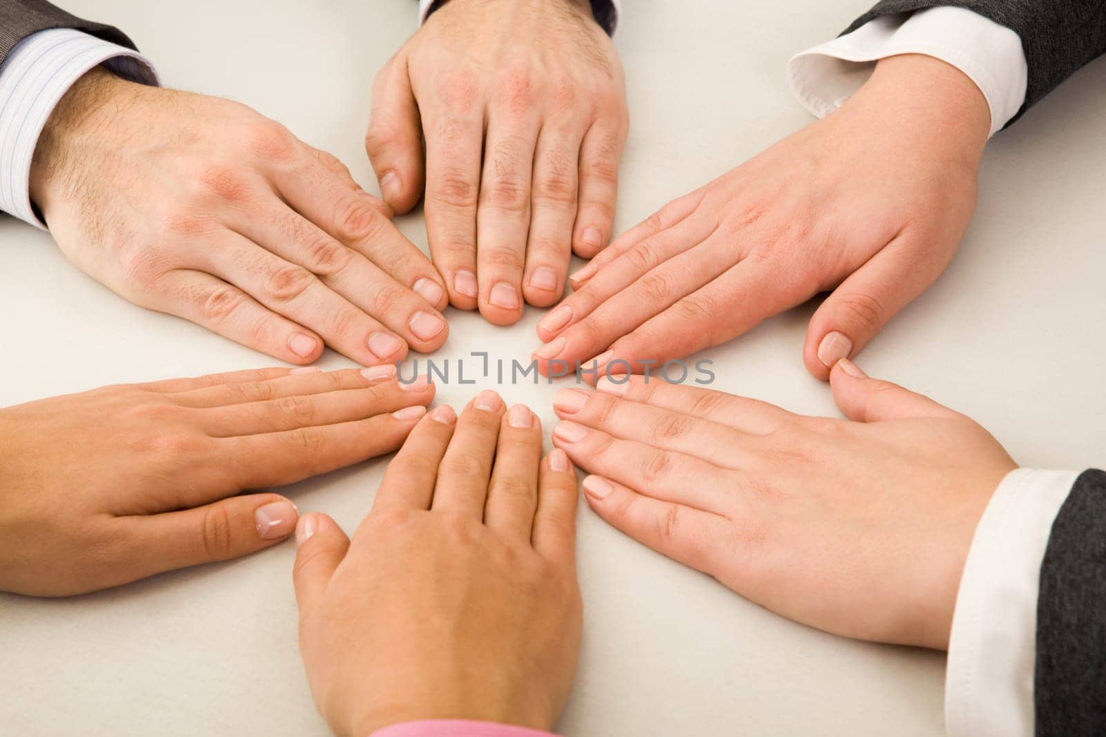 Image of business partners hands making circle on table
