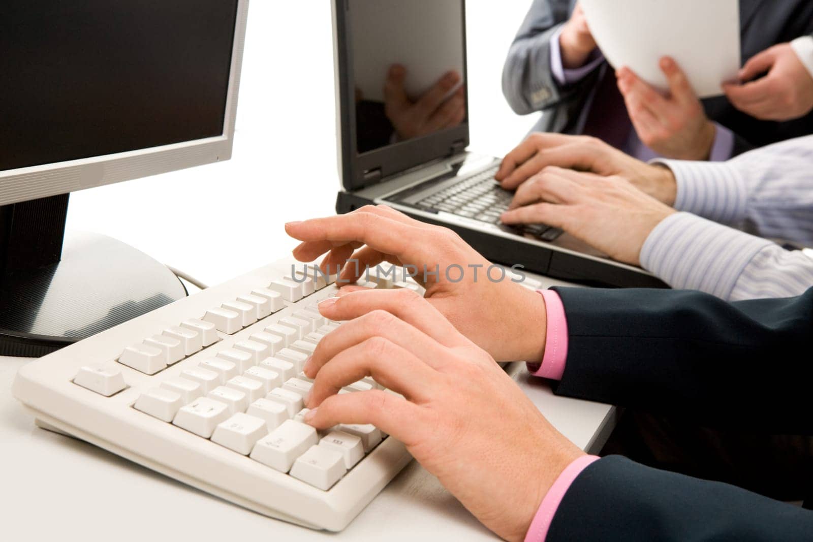 Photo of females hands touching keys of computer board during briefing on background of human hands