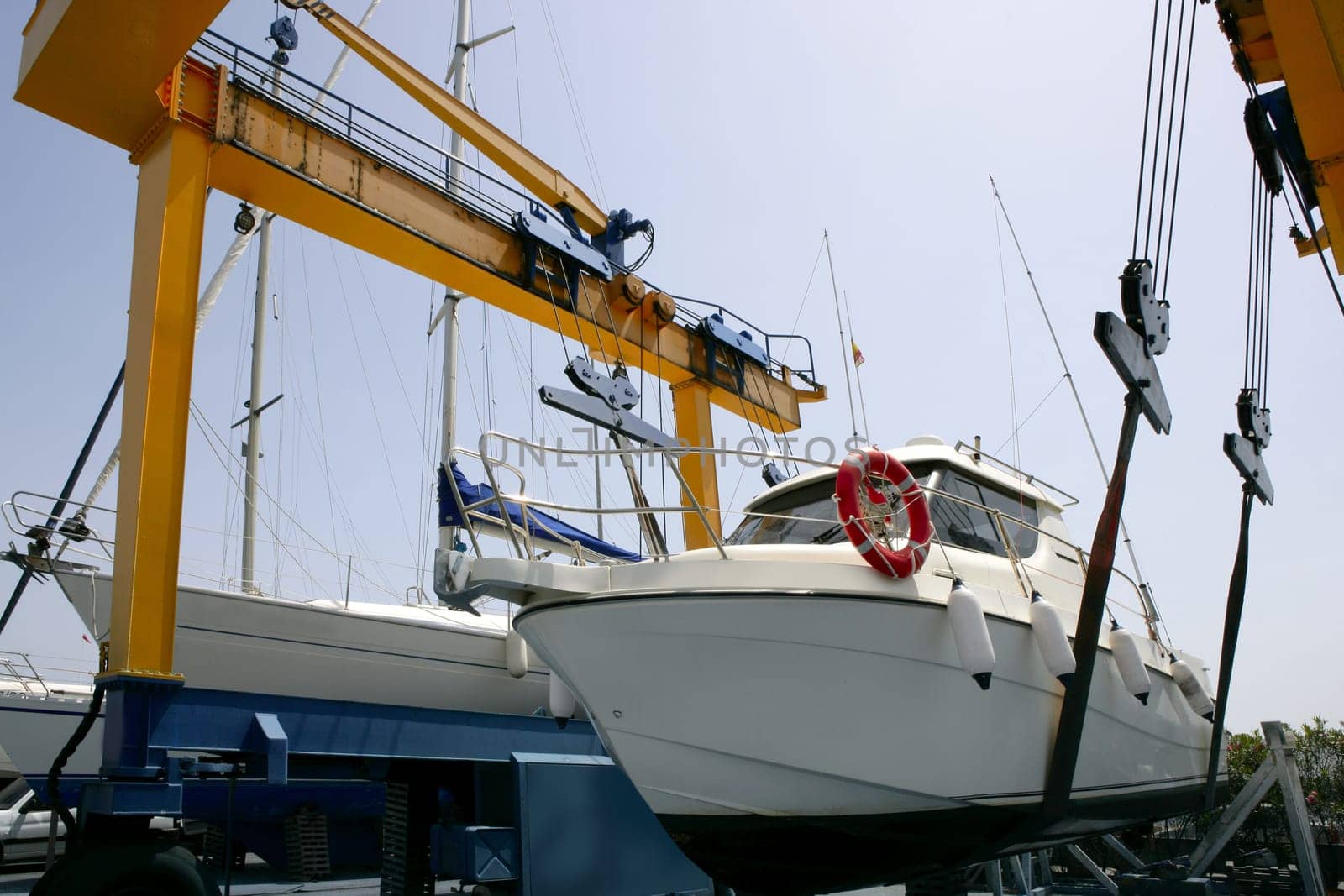 Dock crane elevating a fishing boat in Mediterranean marina