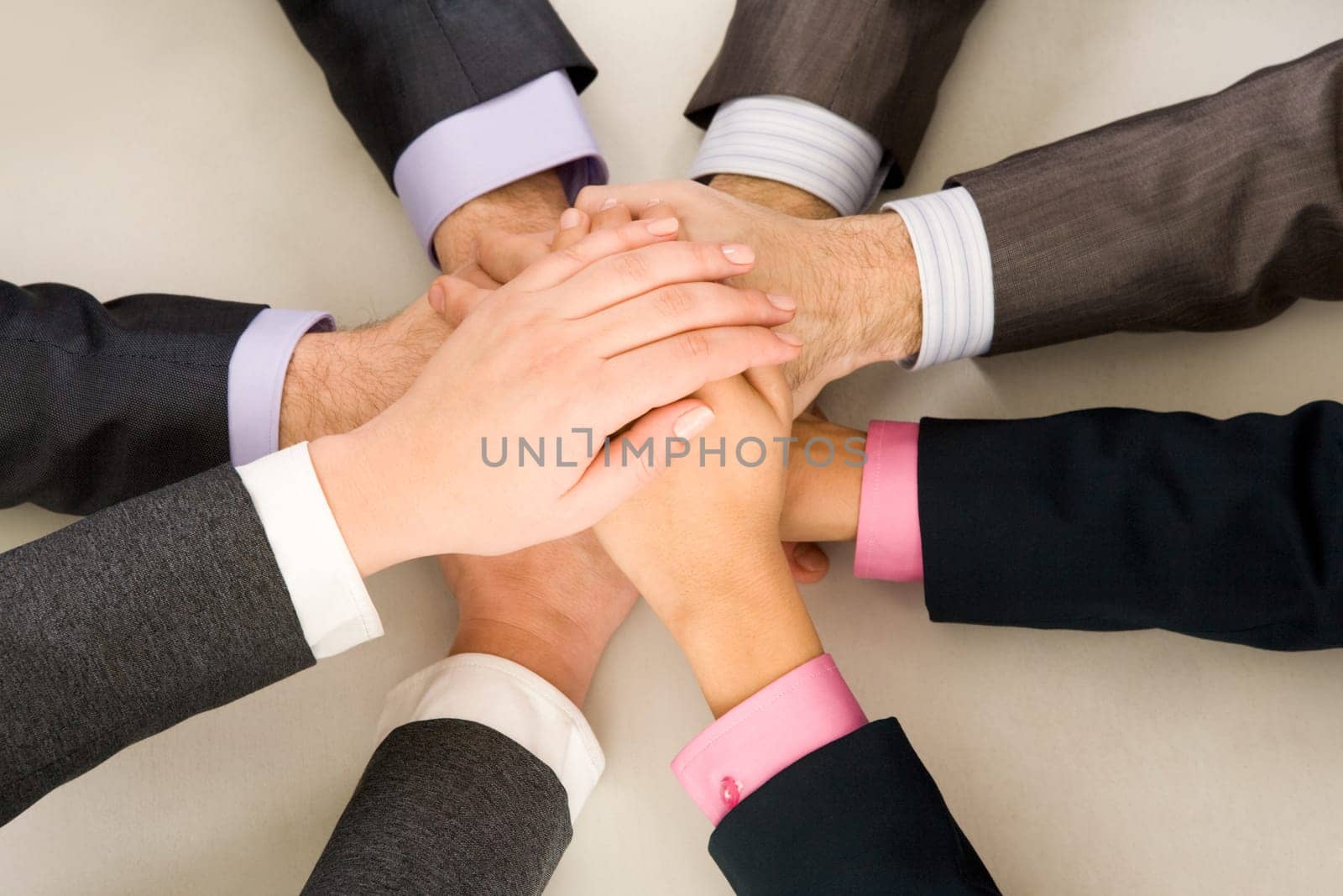 Image of business people hands on top of each other symbolizing support and power