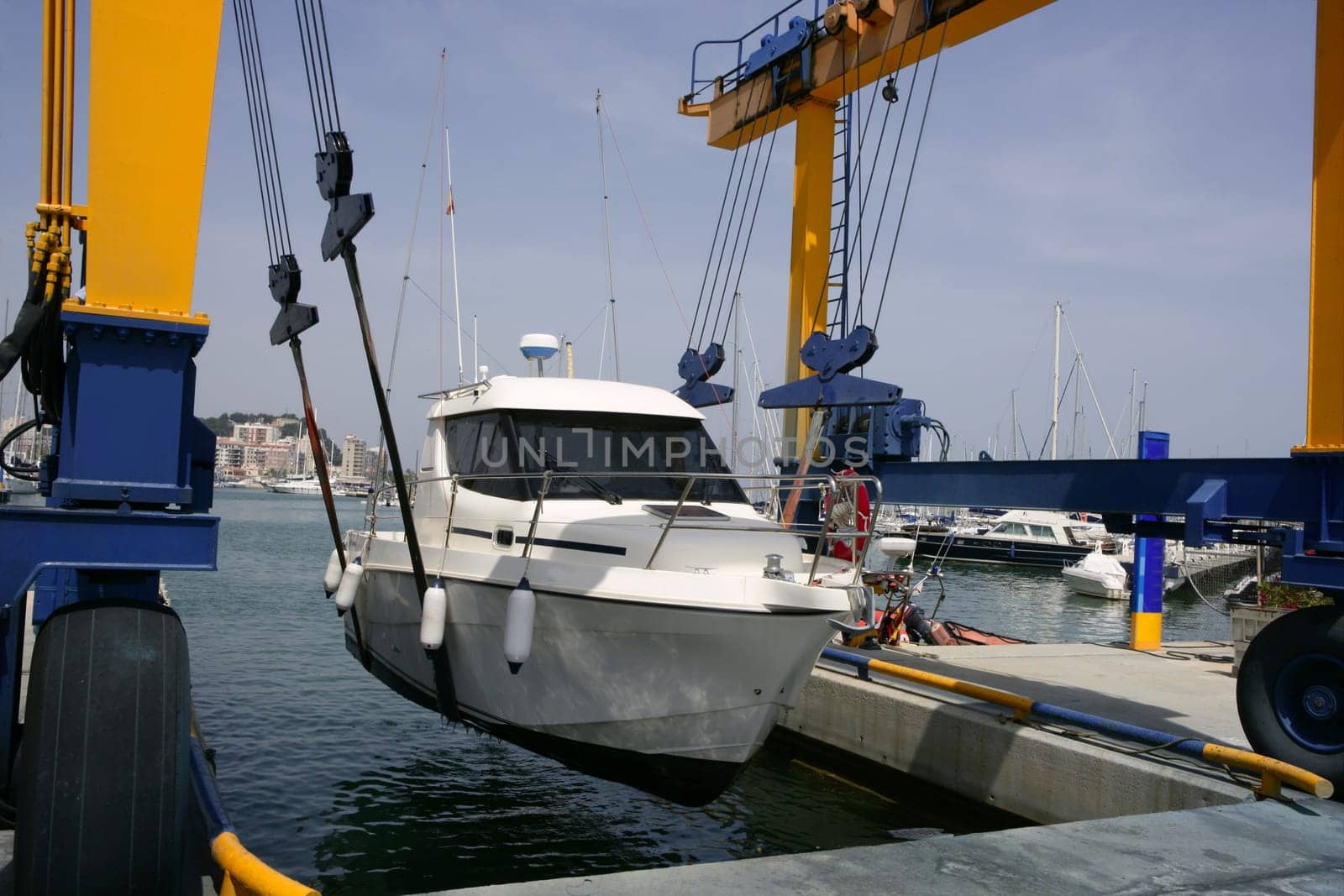 Dock crane elevating a fishing boat in Mediterranean marina