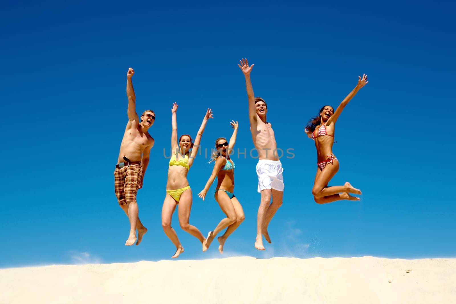 Happy group of young jumping people with hands up