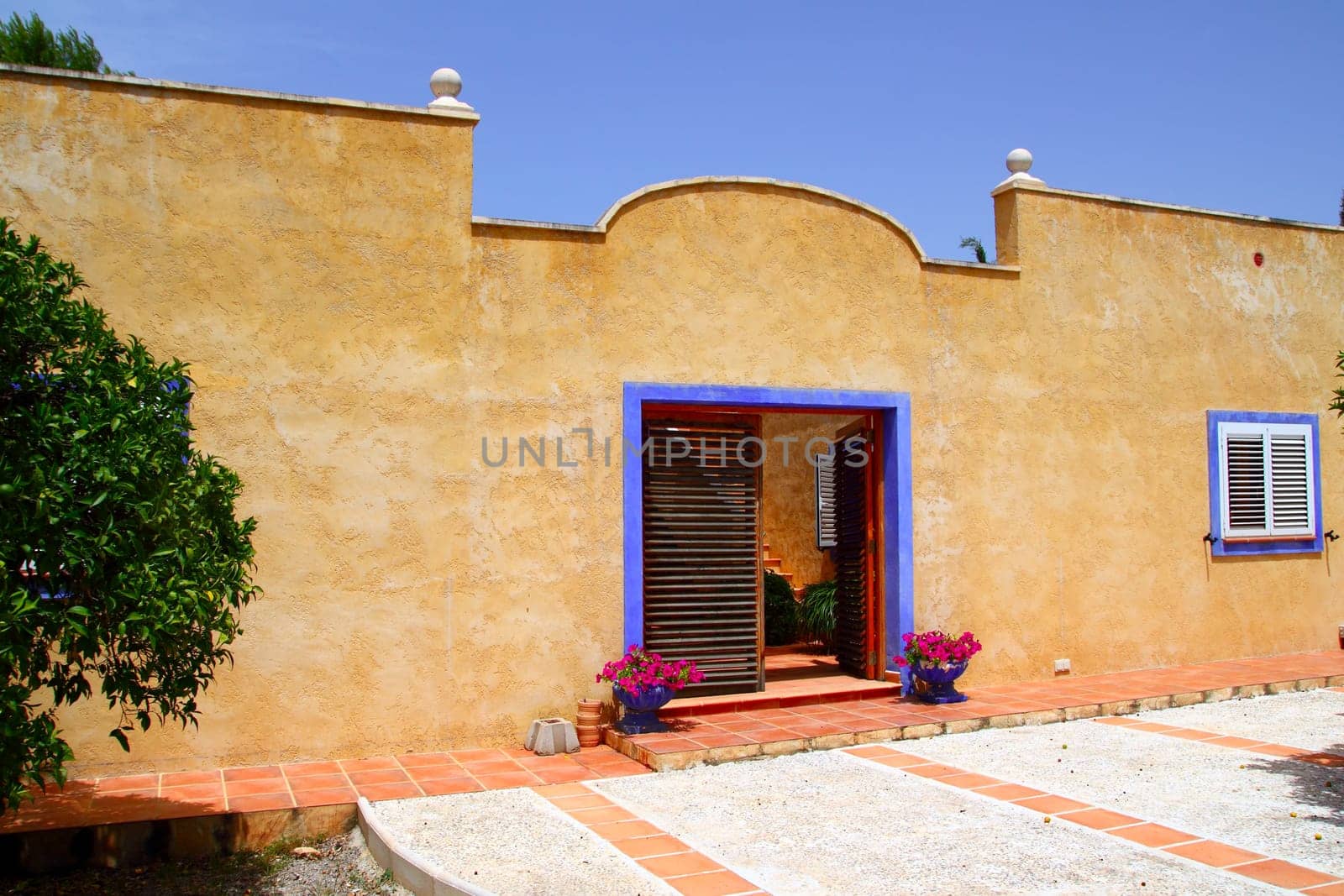 Beautiful house facade yellow blue door frame mediterranean style