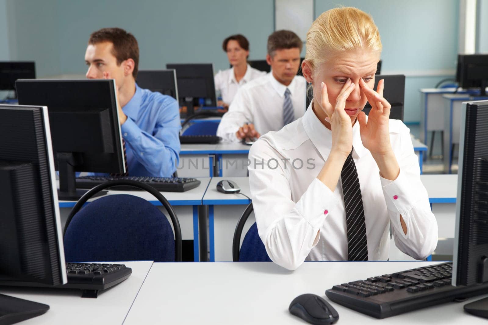 Businesspeople sitting at tables with computers and having break