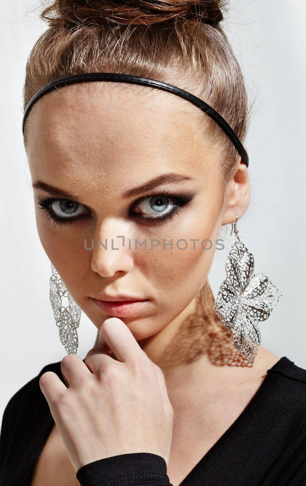 Gorgeous woman with fantasy earrings looking at camera