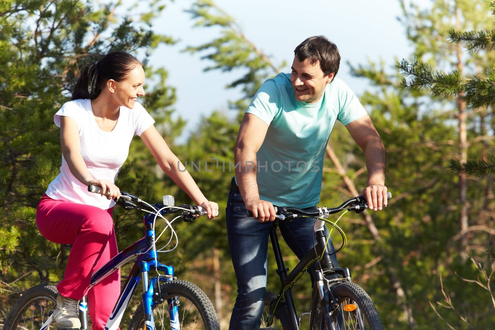 A young happy couple riding bicycles together