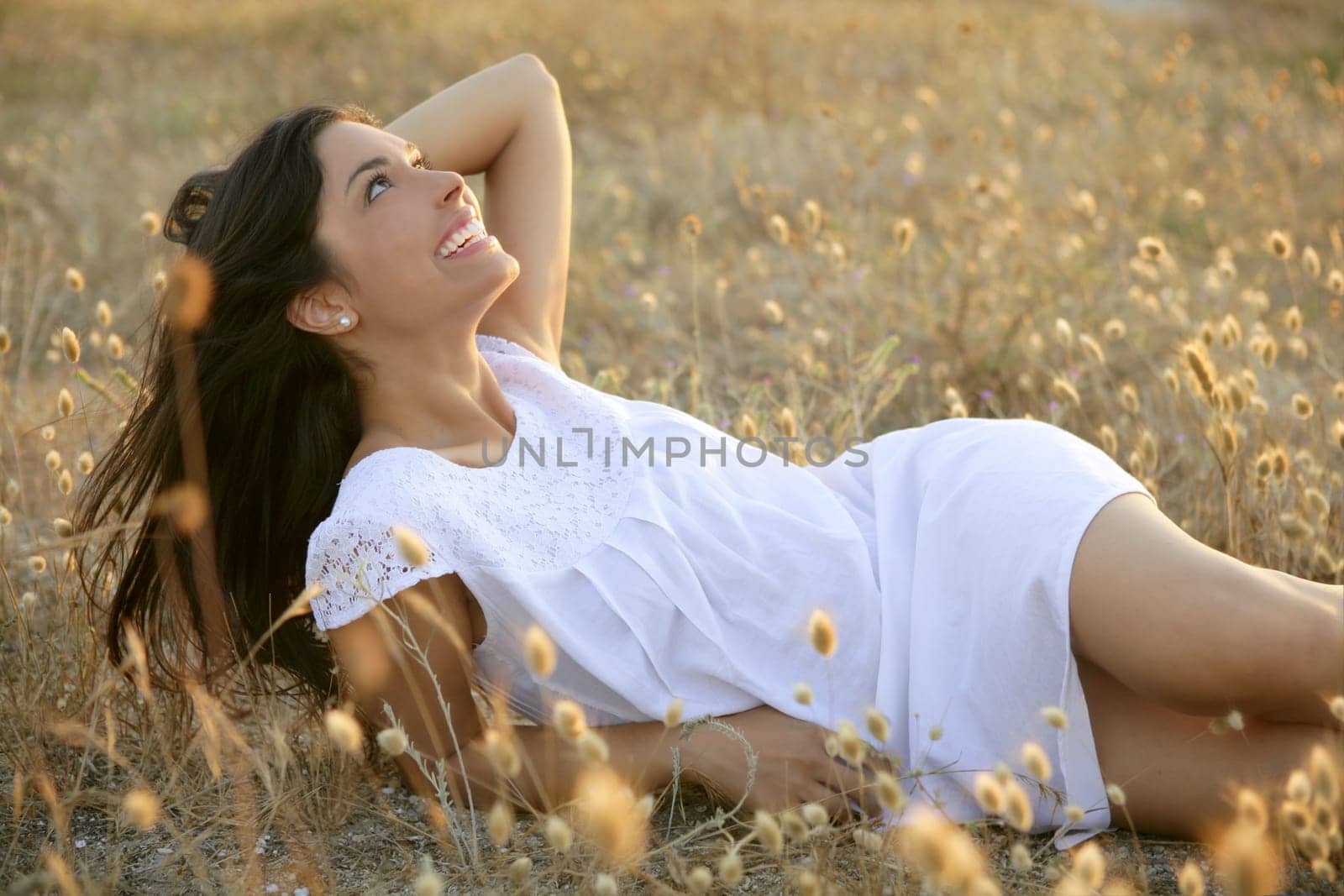 Beautiful indian brunette having a rest on a golden summer field