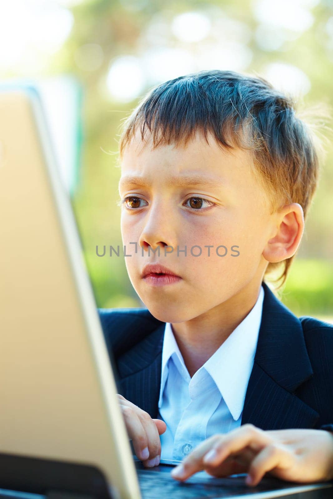Portrait of smart boy working with laptop with attention